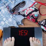woman weights herself before summer vacation