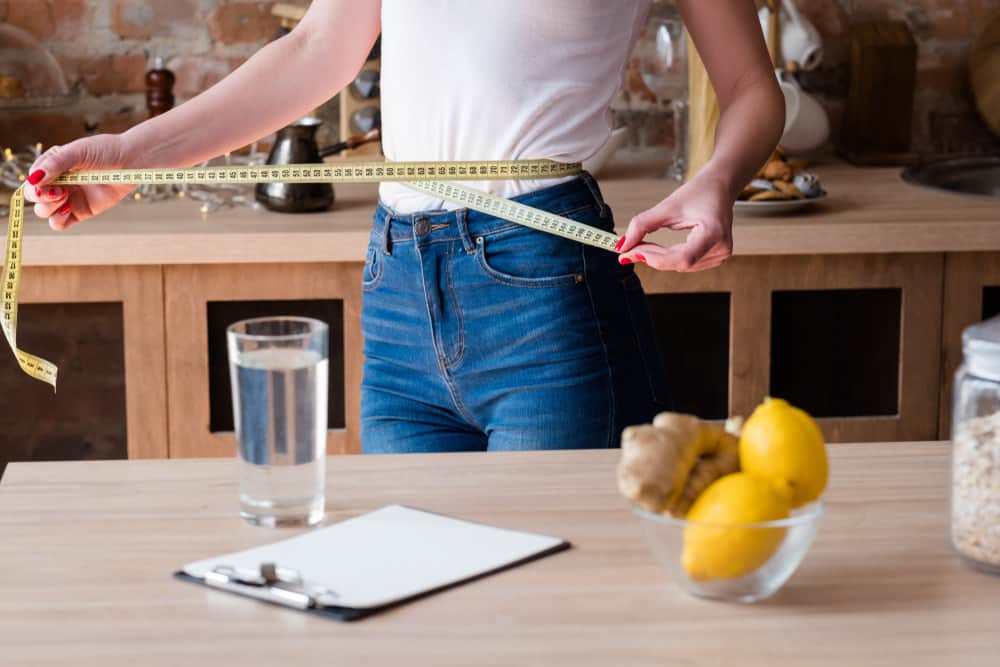 woman measuring her waist